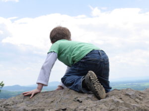 Crawling child on top of a hill as an image for achievements and successes